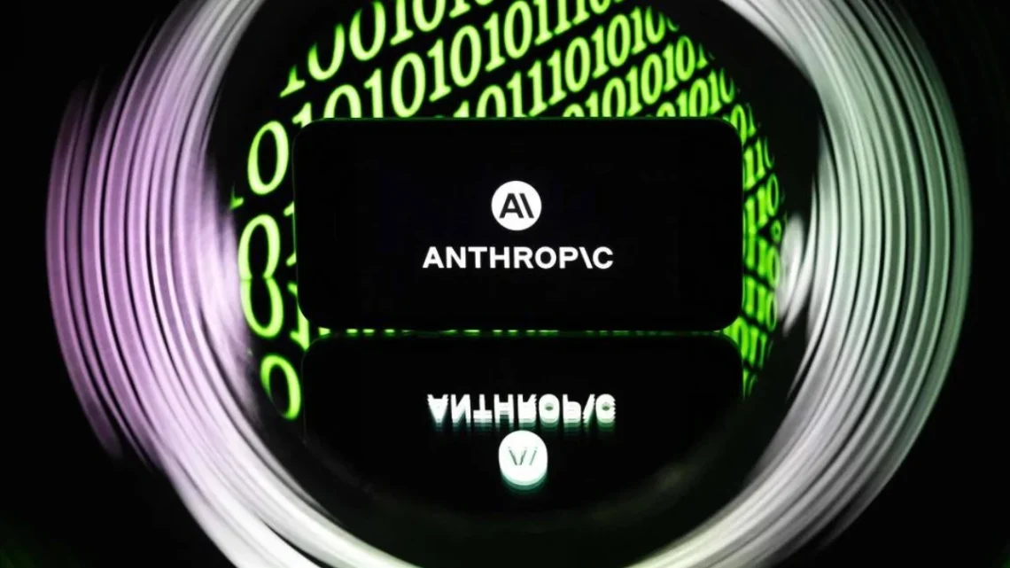 Tela exibe o logotipo da Anthropic com o símbolo AI em branco sobre fundo preto. Ao redor, números binários verdes aparecem desfocados, formando um círculo luminoso.
Tela de smartphone exibindo símbolo da startup Anthropic - Sebastien Bozon - 21.abr.26/AFP
