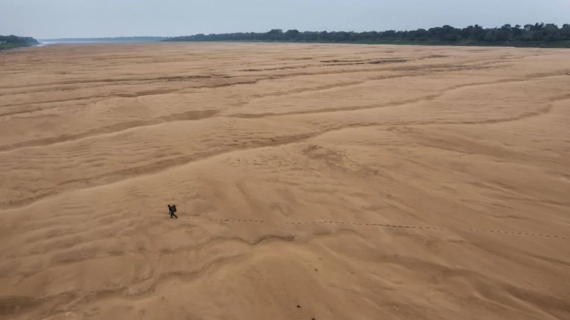 Pescador atravessa caminhando o leito seco do rio Solimões, próximo à comunidade indígena Porto Praia, em Tefé (AM), durante a seca extrema que atingiu a amazônia ocidental durante o último El Niño - Lalo de Almeida - 13.out.23/Folhapress